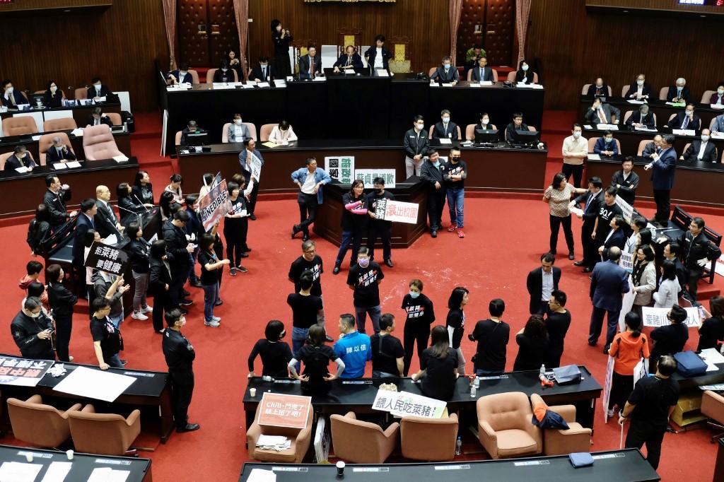 Legislators from the main opposition Kuomintang display placards reading 'Feed people with Ractopamine pork' to ask Premier Su Tseng-chang to step down during a demonstration at the Parliament in Taipei on Nov 27. Photo: AFP