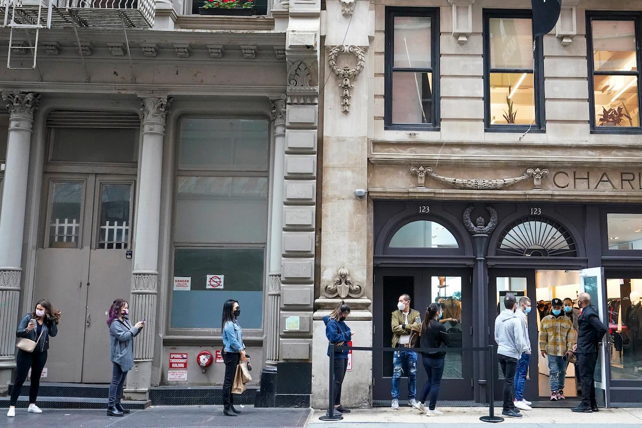 Shoppers in New York observe physical distancing rules as they line up outside of a store in the Soho neighbourhood. Photo: AP
