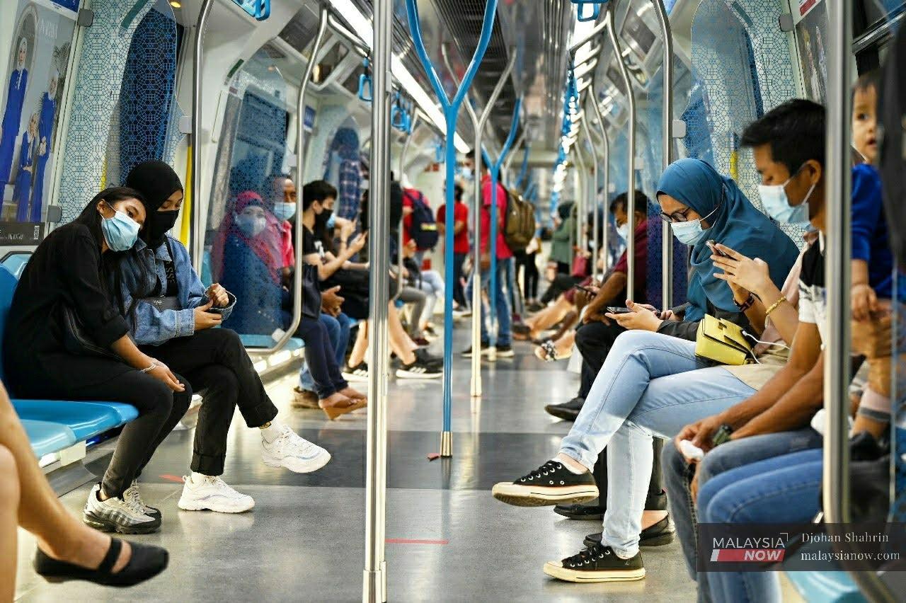 Commuters on the MRT wear face masks to ward off the spread of Covid-19 at the Merdeka station in Kuala Lumpur.