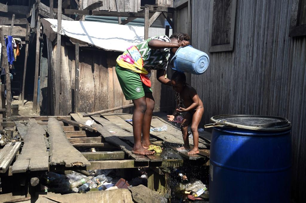 A woman washes her child in a makeshift home in the Makoko riverine slum settlement in Lagos, Nov 27. Photo: AFP