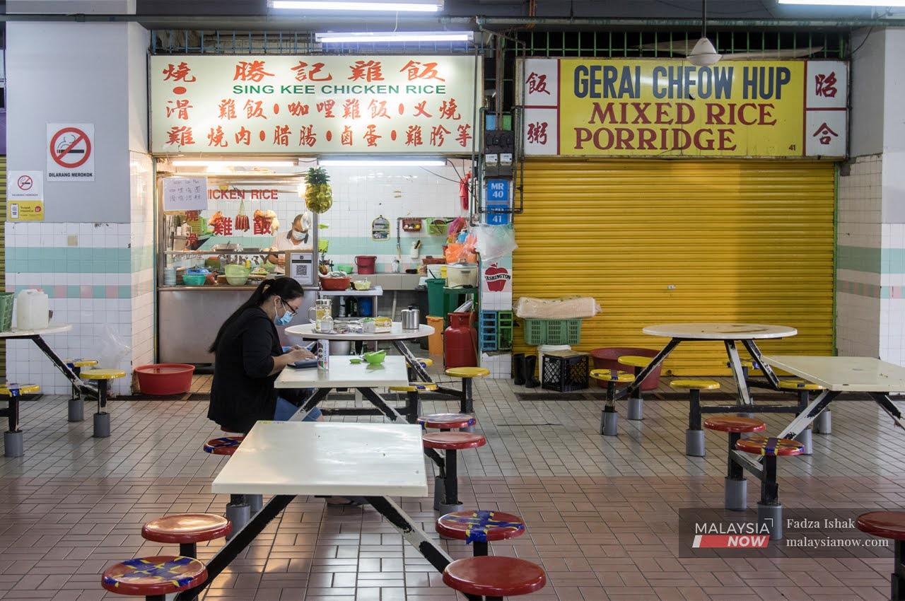 A woman eats at a food court in Petaling Jaya, Selangor during the conditional movement control order period.