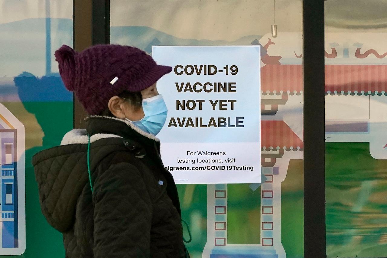 A woman wearing a face mask passes a sign at a pharmacy stating that Covid-19 vaccines are not yet available in San Francisco, Dec 2. Photo: AP