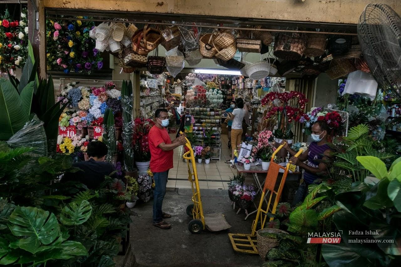 Kelihatan dua orang pekerja warga asing sedang bekerja di Pasar Chow Kit, Kuala Lumpur.