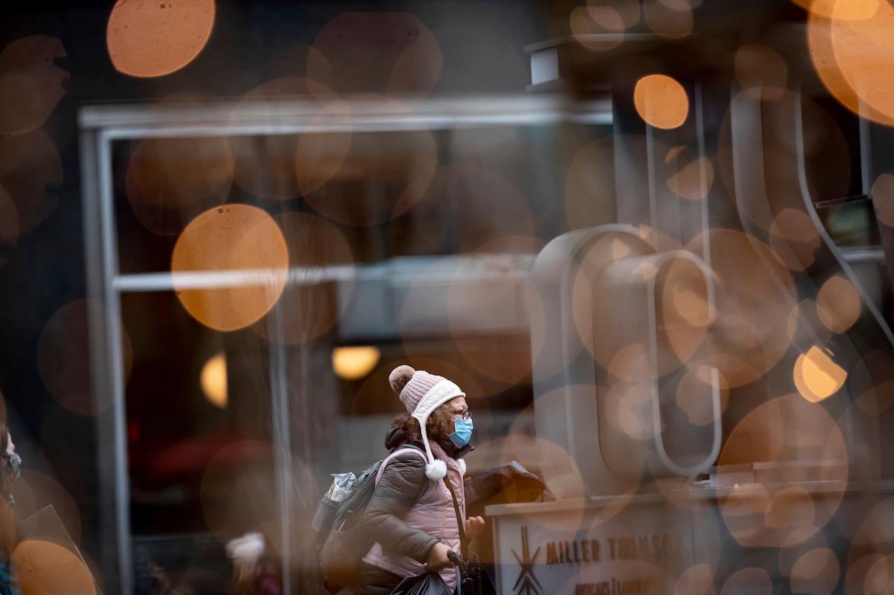 A woman wearing a face mask walks in downtown Vancouver, Canada. Photo: AP