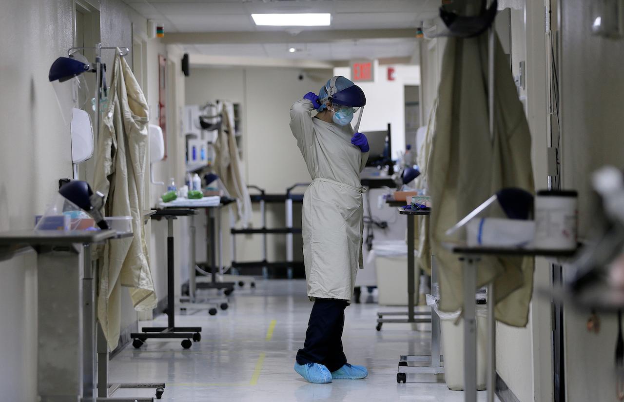A health worker at a hospital in El Paso, Texas changes personal protective equipment before continuing her rounds. Photo: AP