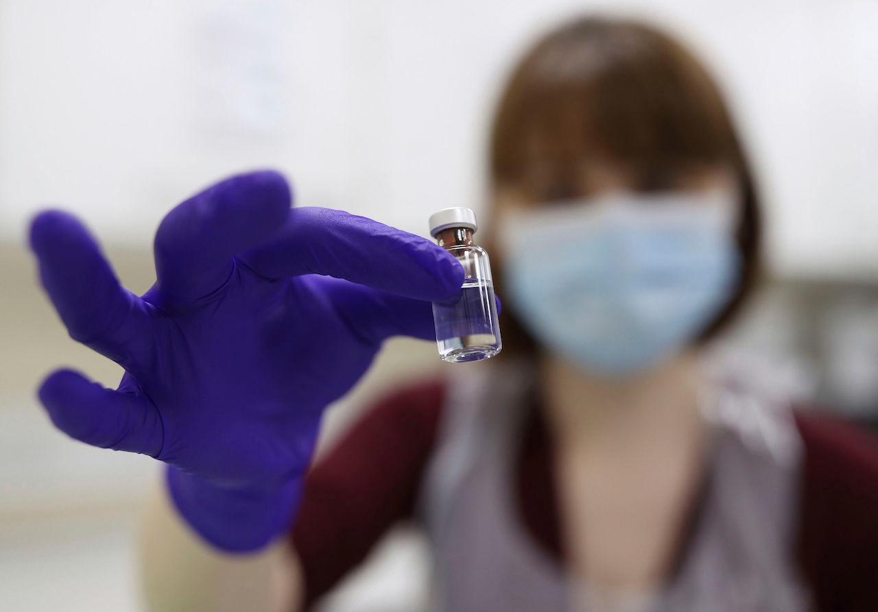 A pharmacy technician at a hospital in London simulates the preparation of the Pfizer vaccine to support staff training ahead of the rollout, Dec 4. Photo: AP
