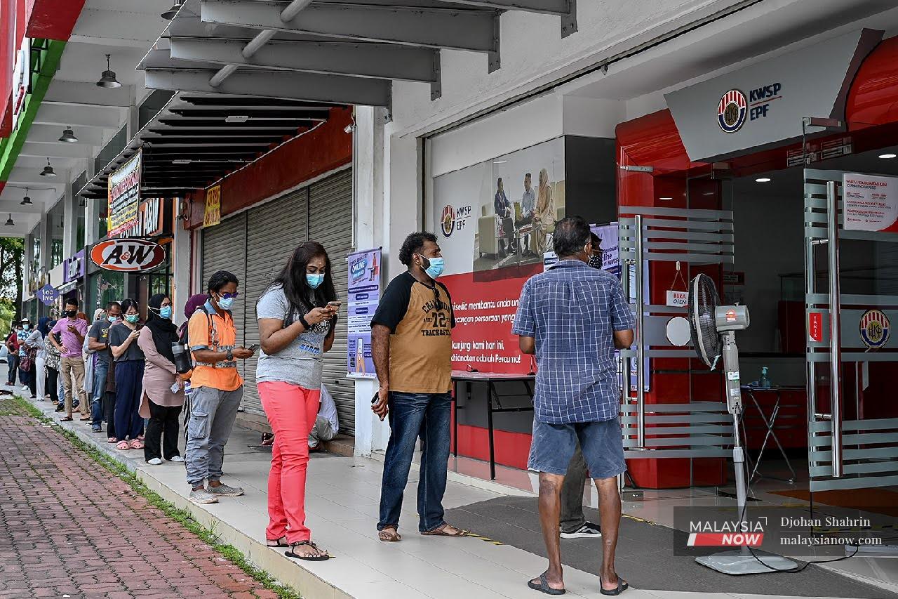 People line up to enter the EPF branch in Bandar Baru Nilai, Negeri Sembilan to apply for the i-Sinar programme, aimed at helping those who have been financially challenged by the pandemic.