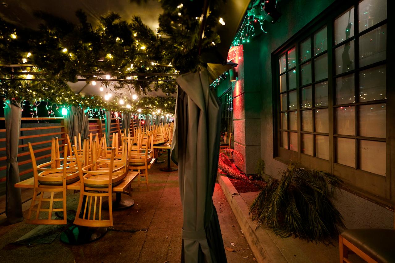 Chairs are stacked on tables in the closed outdoor dining area of a restaurant in California, Dec 7. Photo: AP