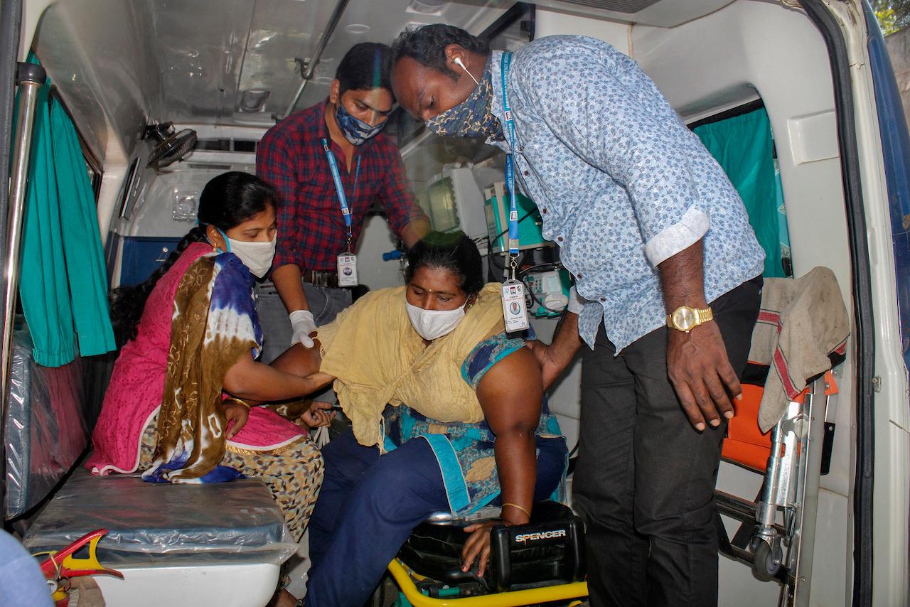 A patient is helped down from an ambulance at the district government hospital in Eluru, Andhra Pradesh state, India, Dec 8. Photo: AP