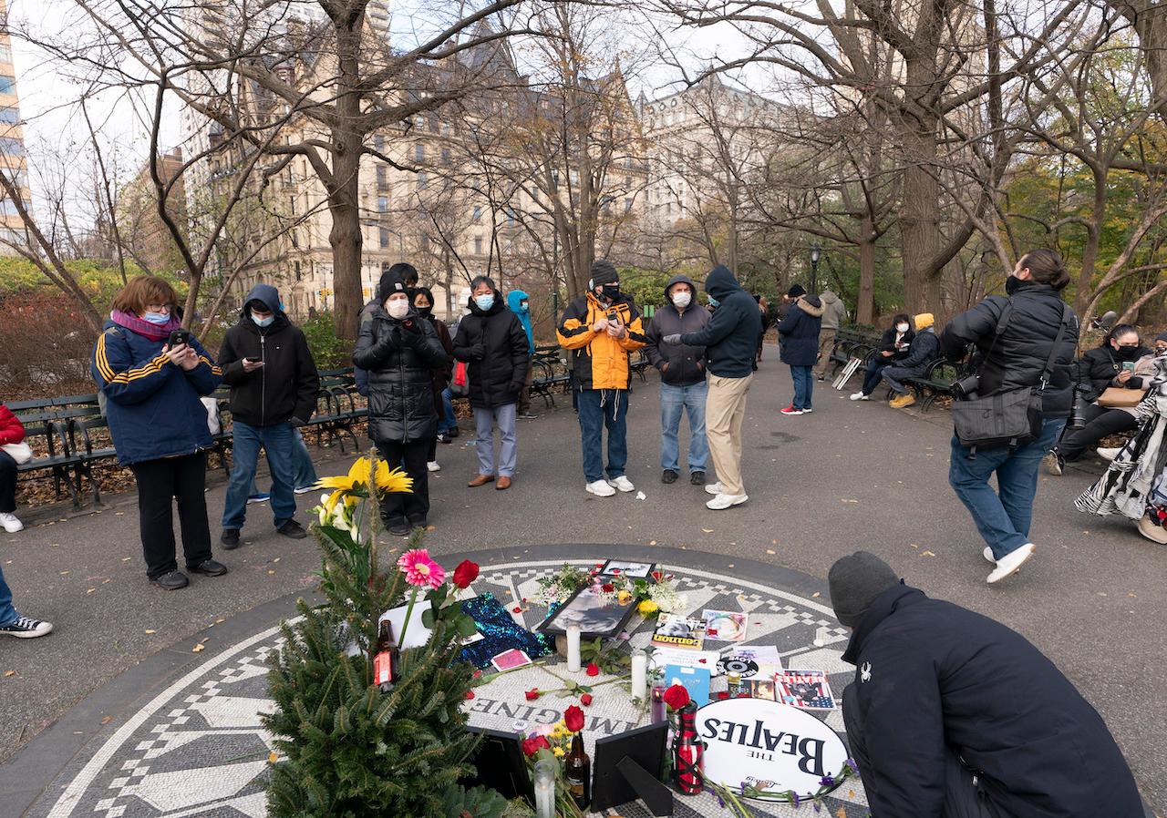 A man places flowers at Strawberry Fields in New York's Central Park to remember John Lennon, Dec 8. Photo: AP