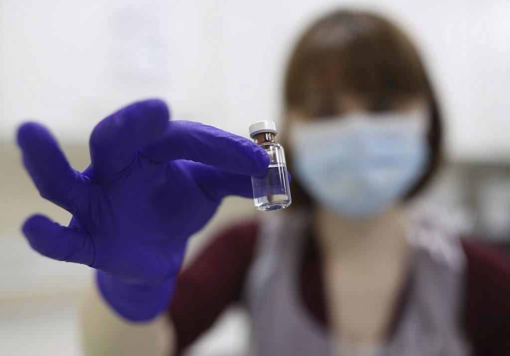 A pharmacy technician at a hospital in London simulates the preparation of the Pfizer vaccine to support staff training ahead of the UK rollout, Dec 4. Photo: AP