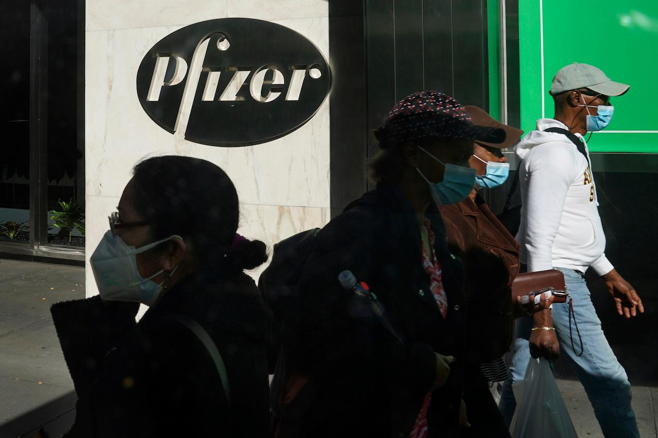 Pedestrians walk past the Pfizer world headquarters in New York on Nov 9. Photo: AP