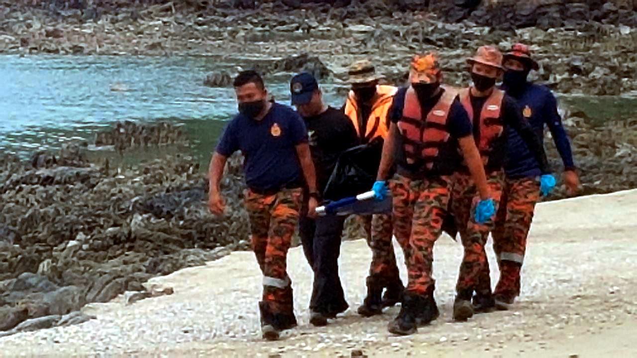 Anggota bomba mengangkat mayat seorang lelaki tempatan yang ditemukan mati lemas di Pantai Tanjung Balau, Kota Tinggi semalam. Mangsa dikenal pasti sebagai Mohd Zulfikrie Buang. Gambar: Bernama