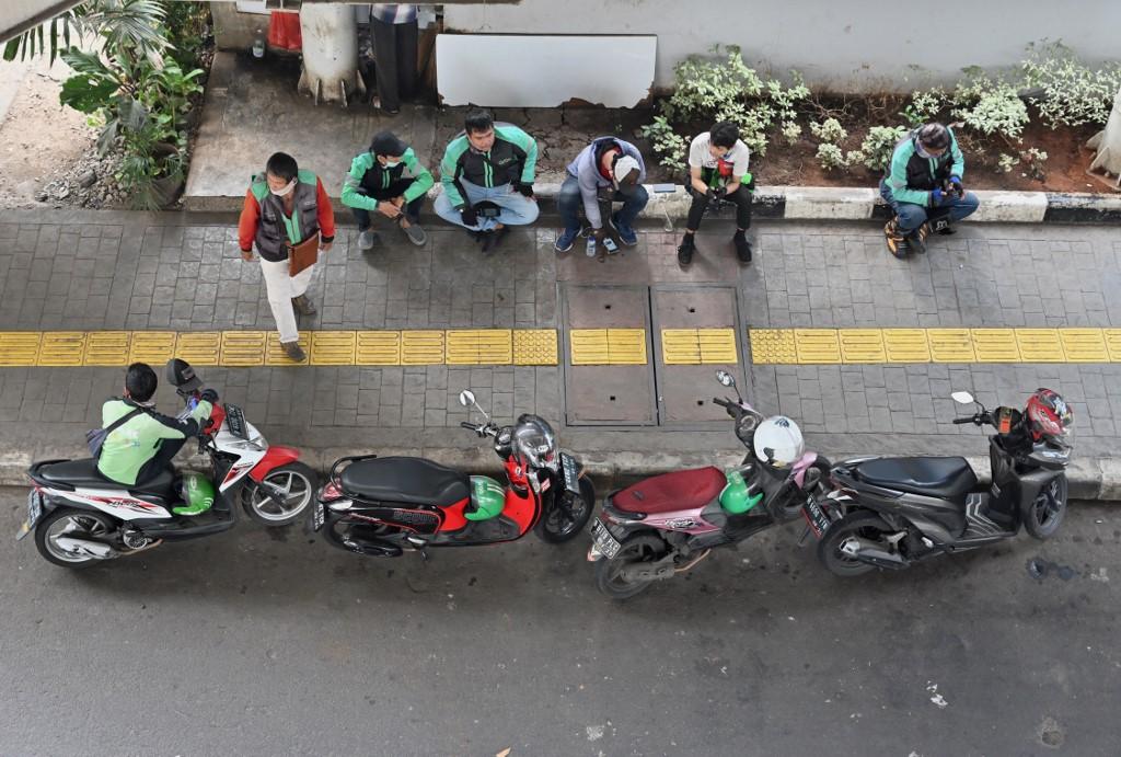 Grab and Gojek drivers wait for passengers in Jakarta, Indonesia, June 24. Photo: AFP