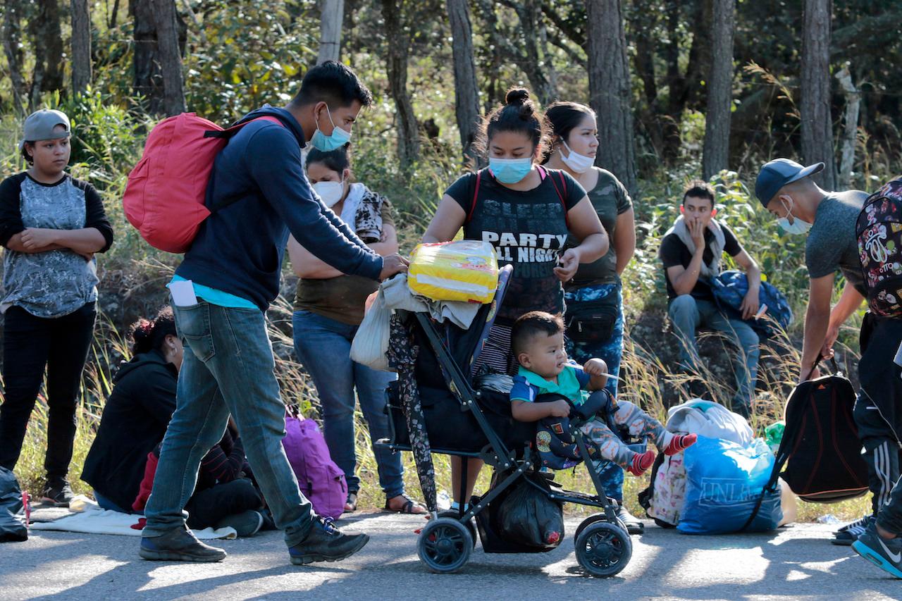 Honduran migrants stand on the side of the road on their way north near Agua Caliente, close to the border with Guatemala, Dec 10. Photo: AP