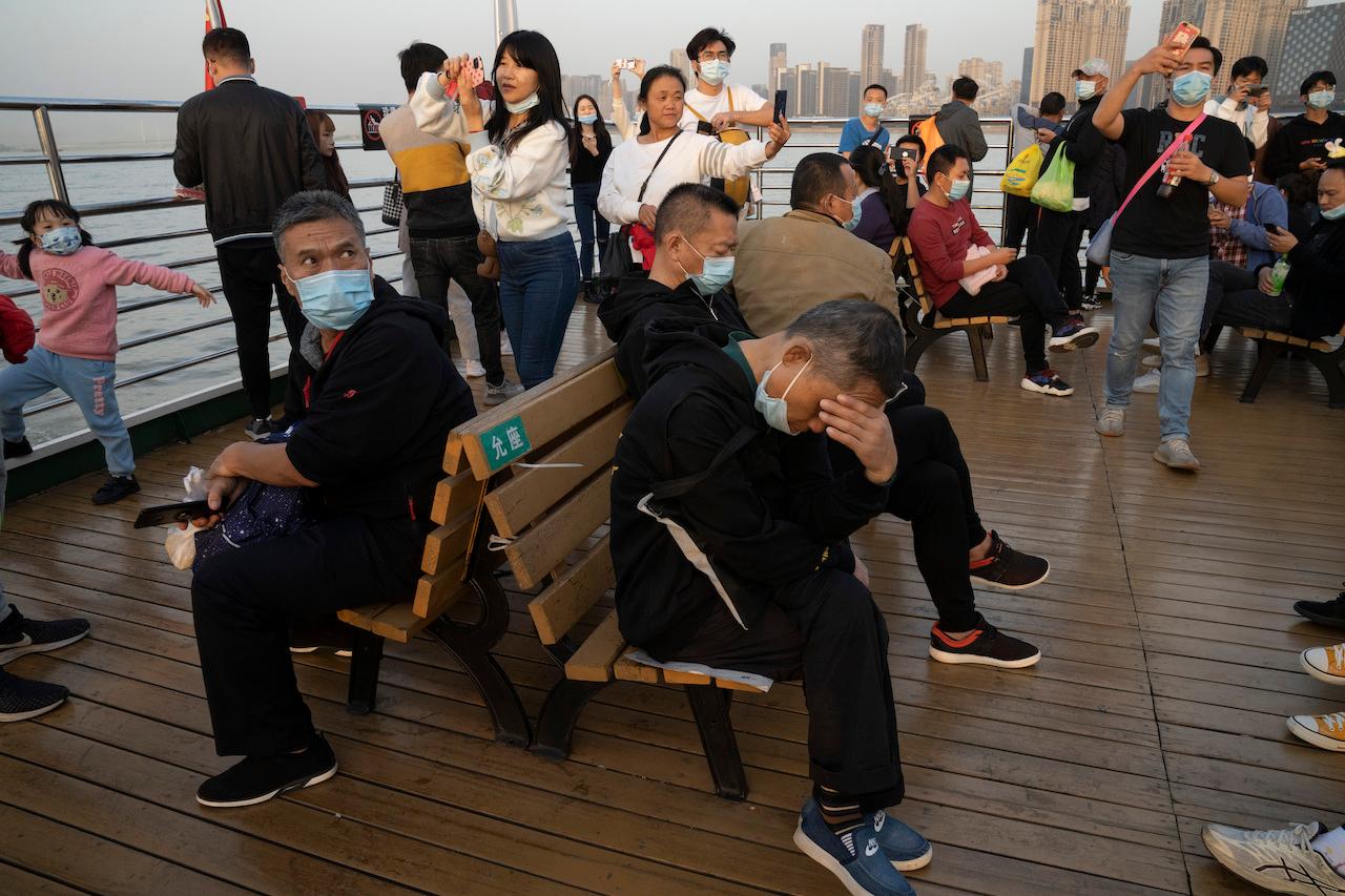 Residents, some wearing masks, ride on a ferry in Wuhan, Oct 22. Photo: AP