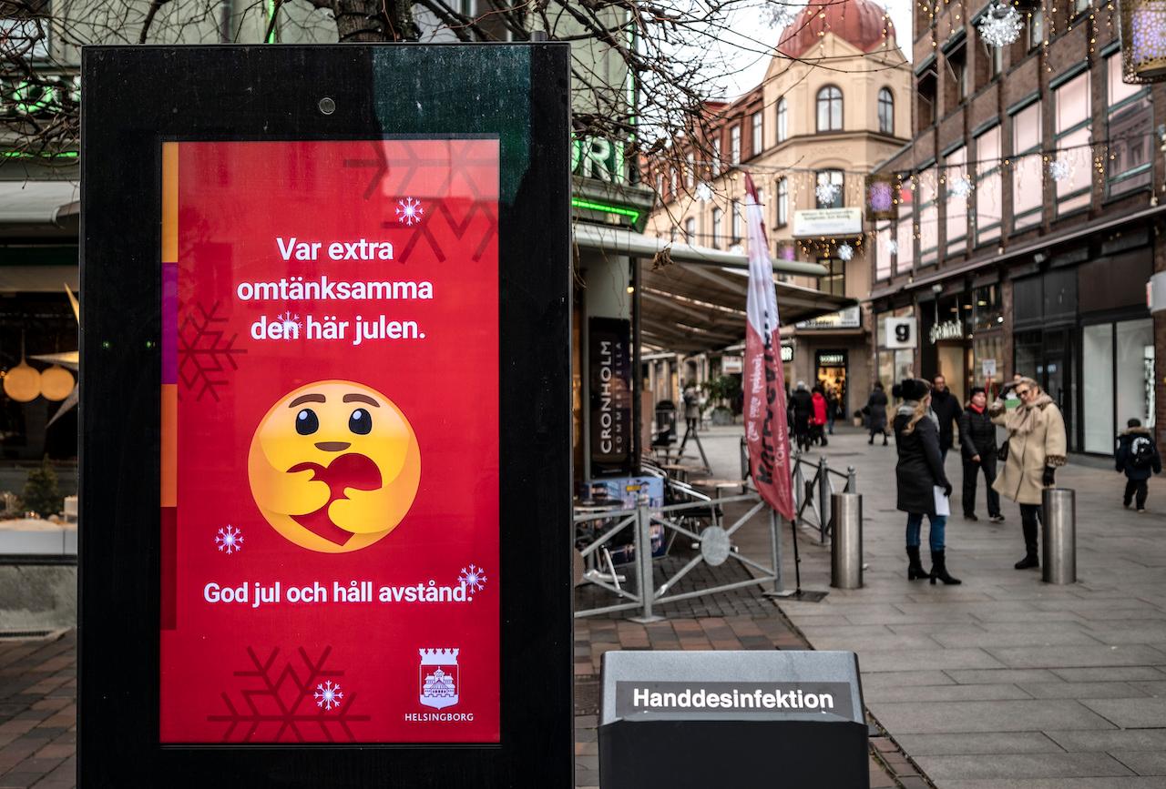 A public information sign wishing people Merry Christmas and asking them to maintain social distancing is seen in a pedestrian shopping street in Helsingborg, southern Sweden, Dec 7. Photo: AP