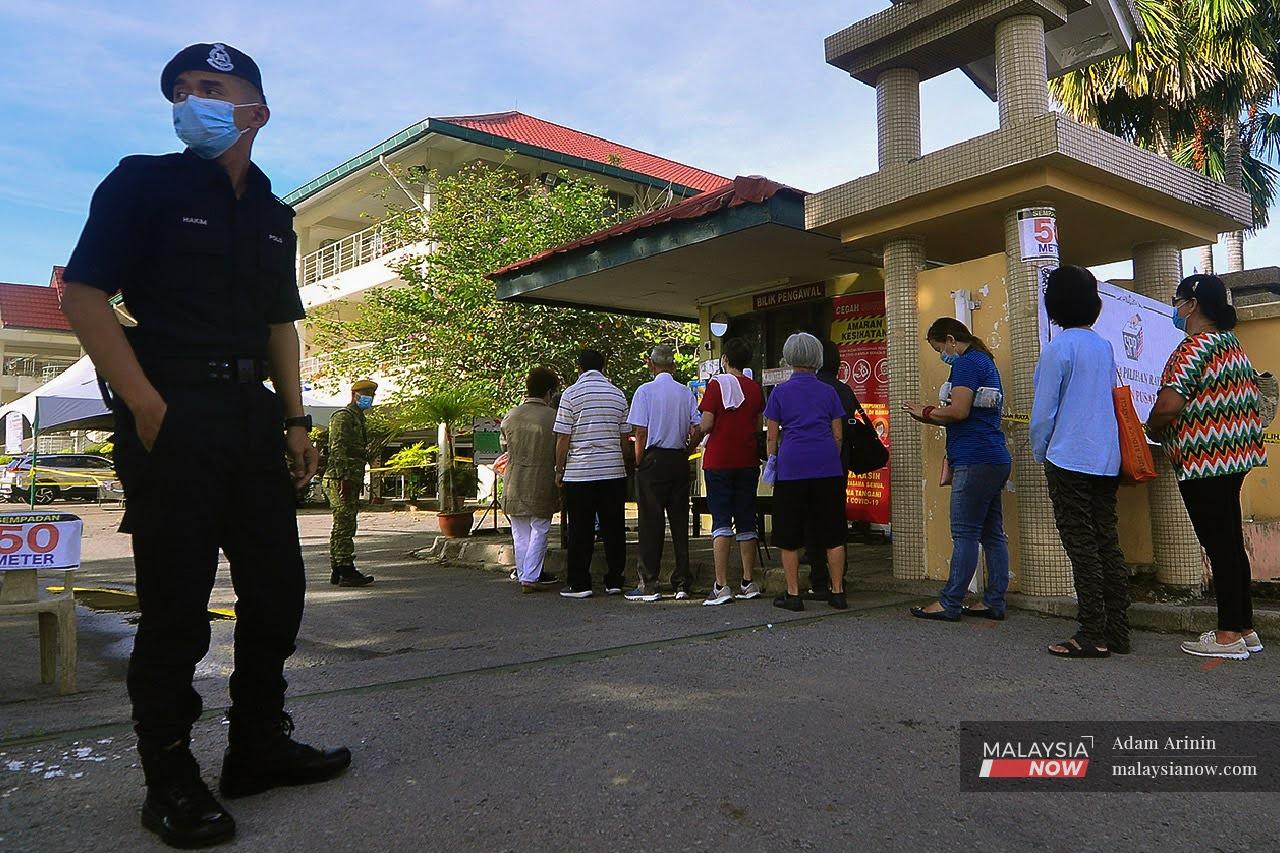 A police officer stands guard at a polling centre in Tanjung Aru, Sabah, during the recent state election in September. Elections could soon look different if the government approves the recommendations made by the Electoral Reform Committee.