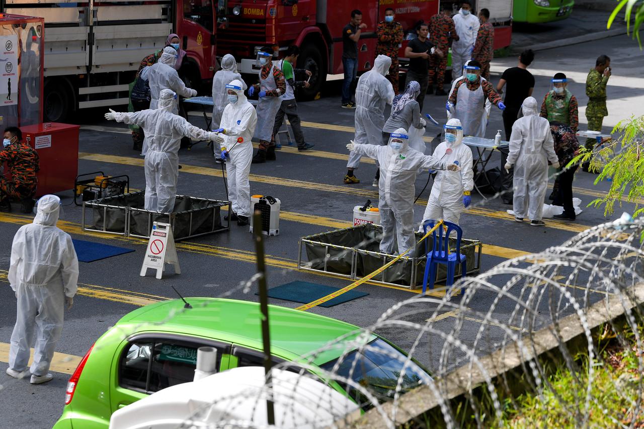 Sebahagian petugas barisan hadapan menjalani proses semburan nyah kuman selepas melakukan Operasi Penguatkuasaan Bersepadu Jabatan Imigresen di sekitar kawasan Perintah Kawalan Pergerakan Diperketatkan (PKPD) di Hentian Kajang pada 24 November lalu. Gambar: Bernama