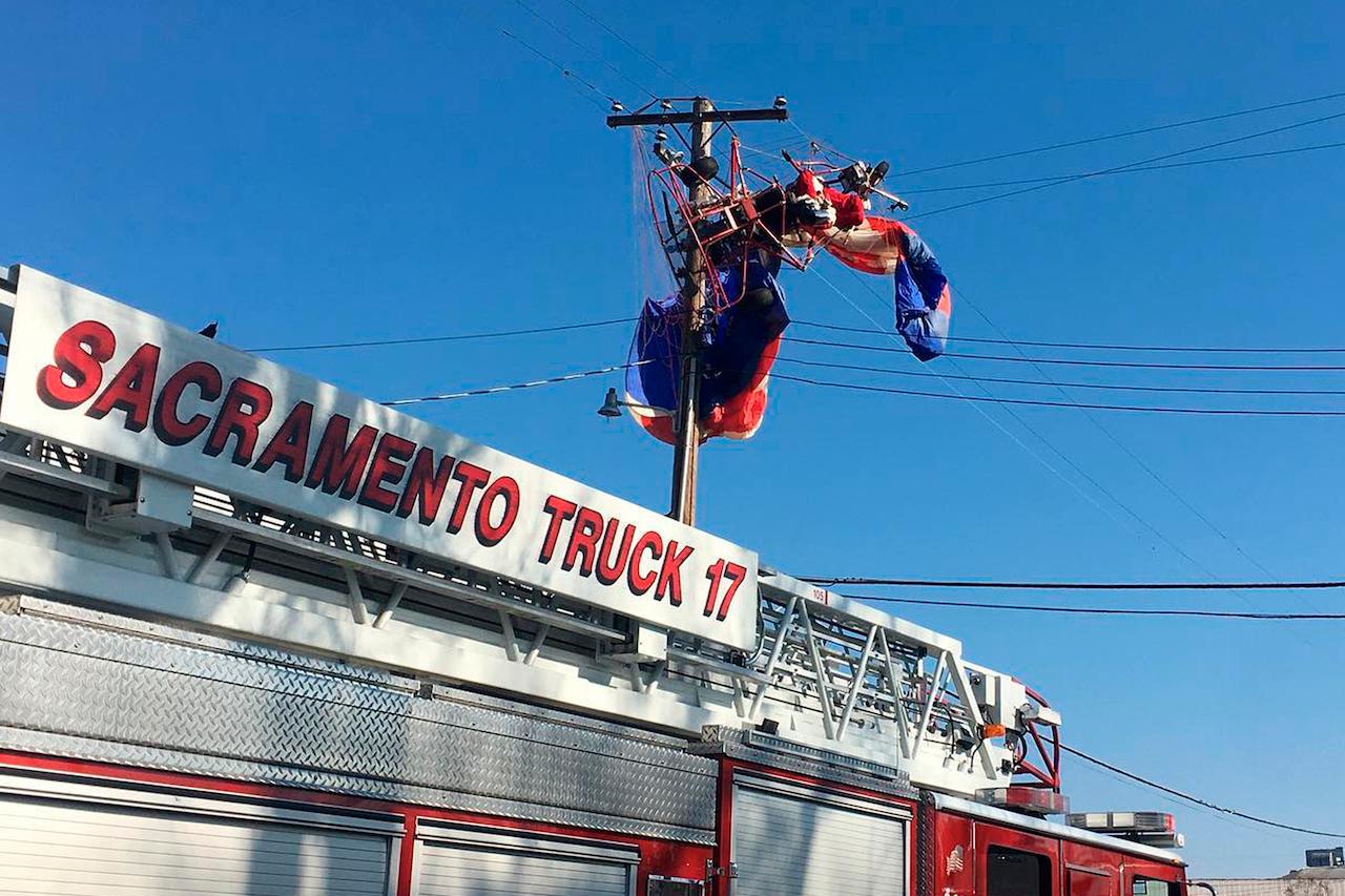 A man dressed as Santa Claus who was flying on a powered parachute on his way to deliver candy canes to children is seen stuck on power lines in Rio Linda, California, Dec 20. Photo: AP