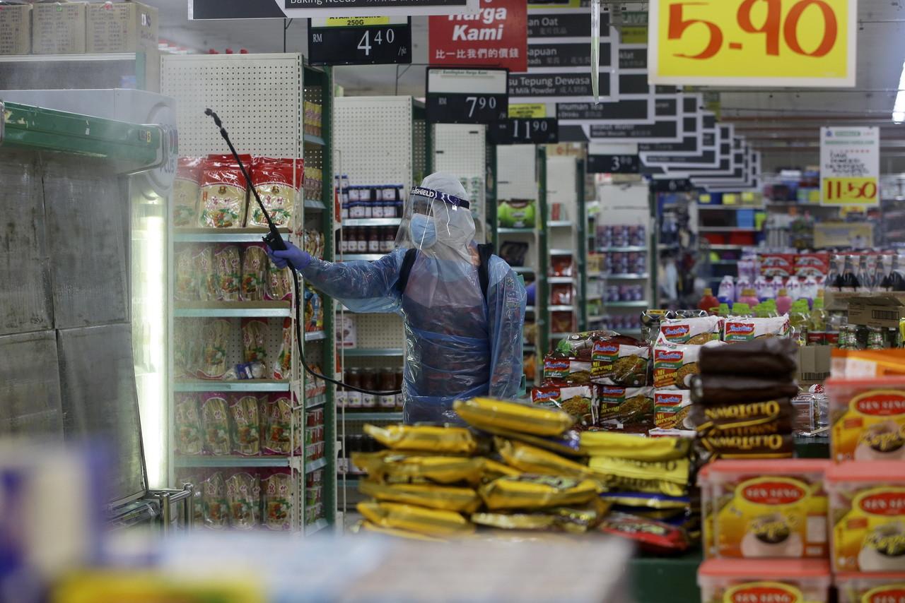 A health worker sprays sanitiser at a supermarket in Seremban. Photo: Bernama