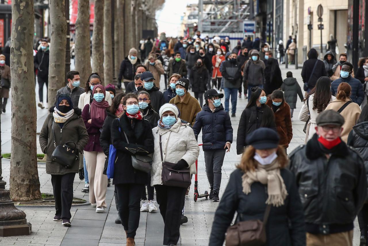 People wearing face makes walk the Champs Elysees avenue in Paris, Dec 26. France has recorded 2,550,864 cases and 62,573 deaths so far. Photo: AP