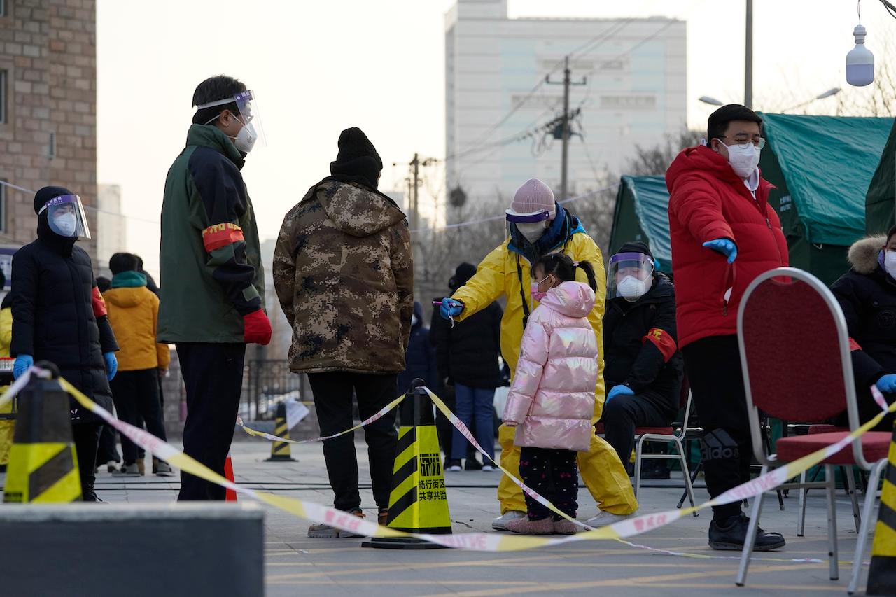 Residents line up for Covid-19 tests at tents set up on the streets of Beijing, Dec 27. Beijing has urged residents not to leave the city during the Chinese New Year holiday in February, implementing new restrictions and mass testings after several coronavirus infections last week. Photo: AP