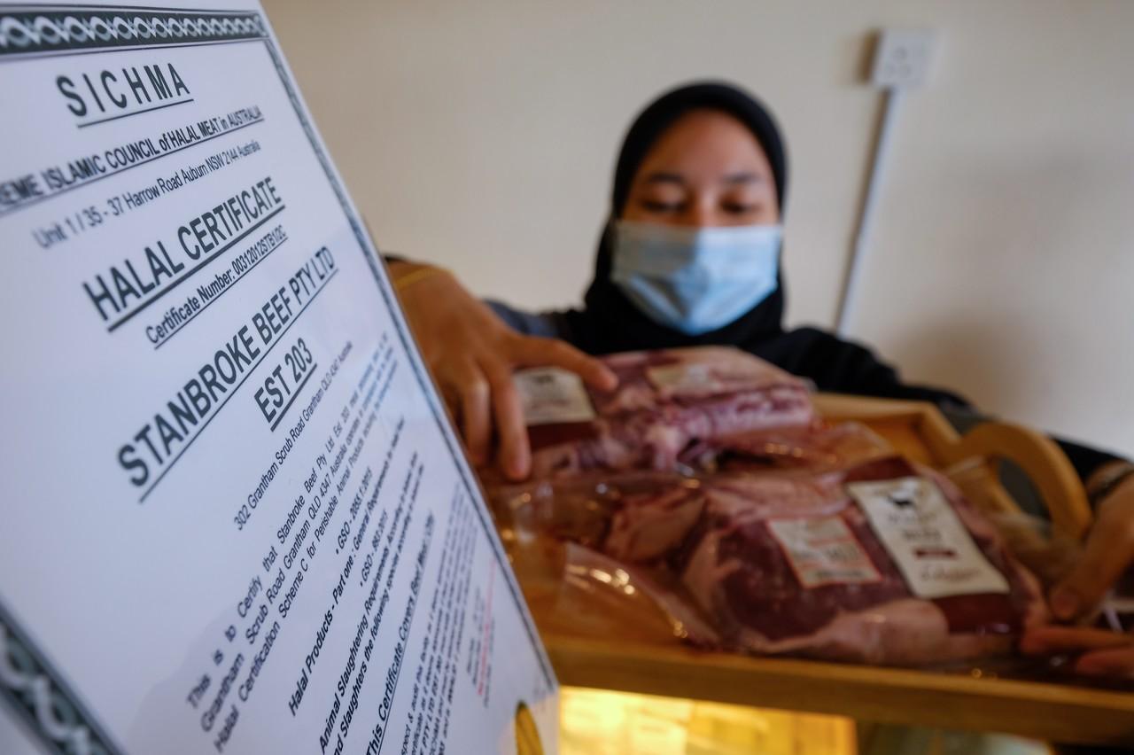 Pekerja premis yang menjual daging import, Siti Aishah Hamid kelihatan menyusun daging import yang dijual di premis D Selection hari ini. Gambar: Bernama