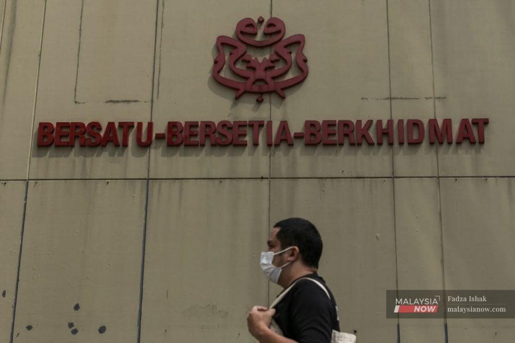 Seorang lelaki berjalan melintasi ibu pejabat Umno di Kuala Lumpur.