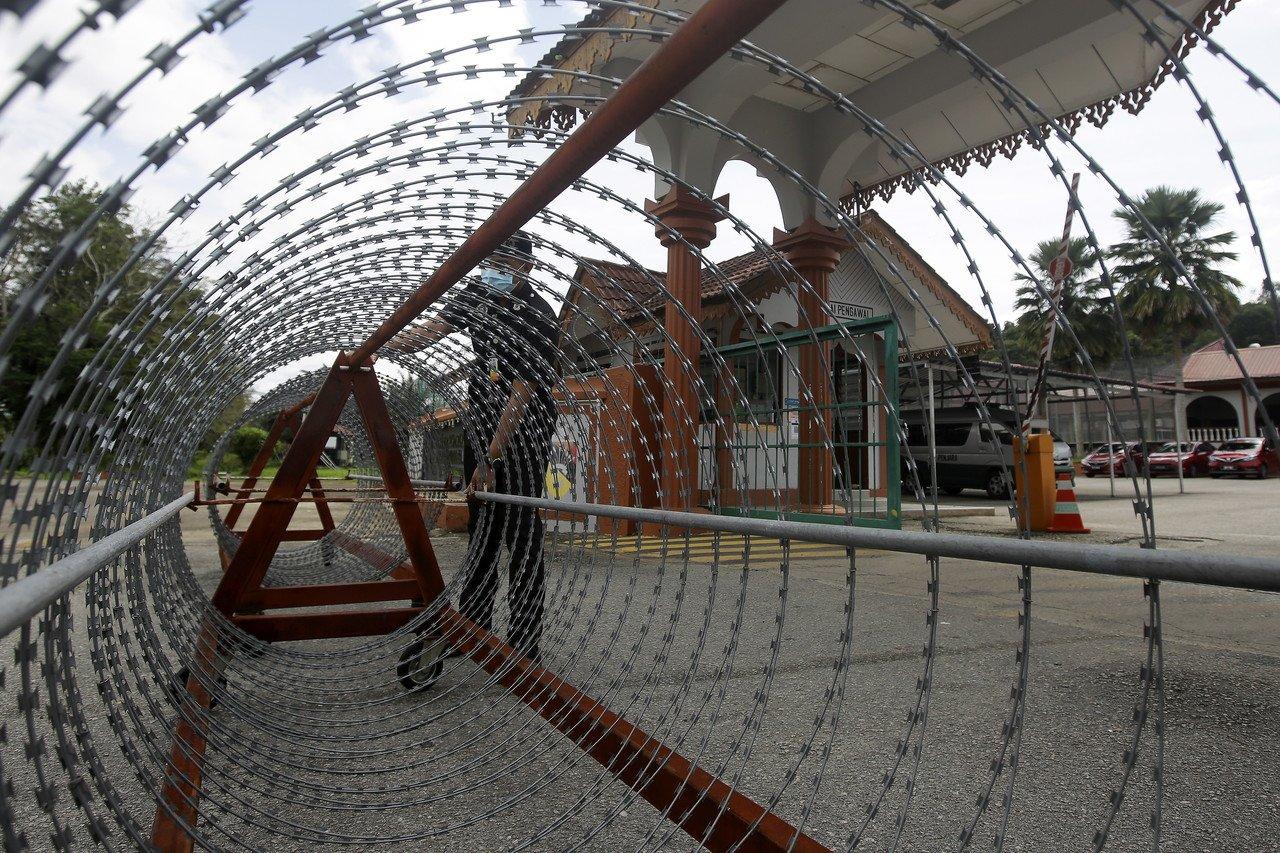 Warden penjara melakukan persiapan penutupan jalan menggunakan kawat duri di perkarangan pintu utama Penjara Jelebu berikutan pelaksanaan Perintah Kawalan Pergerakan Diperketatkan (PKPD) selama 14 hari bermula semalam. Gambar: Bernama
