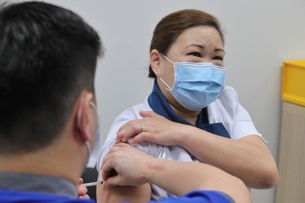 Nurse Sarah Lim receives the first shot of the Pfizer-BioNTech vaccine at the National Centre for Infectious Diseases in Singapore. Photo: AFP
