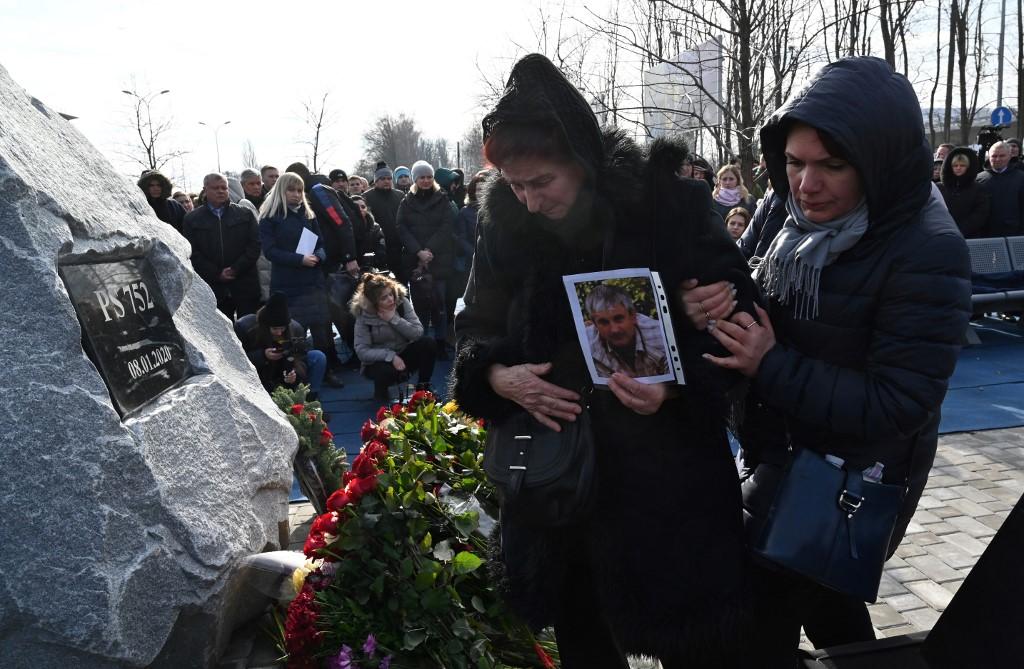 Relatives of the 11 Ukrainians who died in a plane mistakenly shot down by Iran in January react during a ceremony unveiling a memorial stone outside Kiev, Feb 17. Photo: AFP
