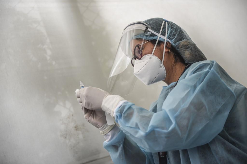 A health worker prepares a syringe to inoculate a volunteer with a Covid-19 vaccine produced by China's Sinopharm during its trial in Lima, Peru, Dec 9. Photo: AFP