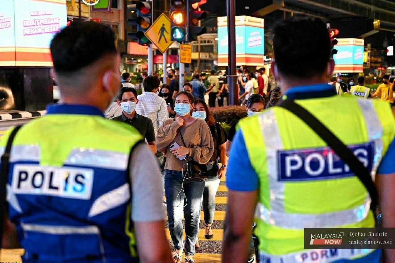 Police monitor the crowd on New Year's Eve at Bukit Bintang, Kuala Lumpur.