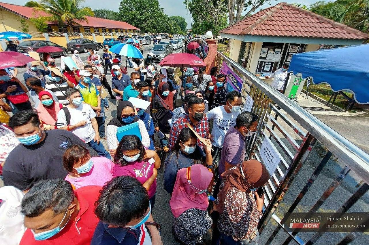 Ibu bapa murid-murid berkumpul di luar pagar Pejabat Pendidikan Daerah Petaling Perdana Seksyen 19, Shah Alam bagi mendapatkan pengesahan pertukaran anak mereka.