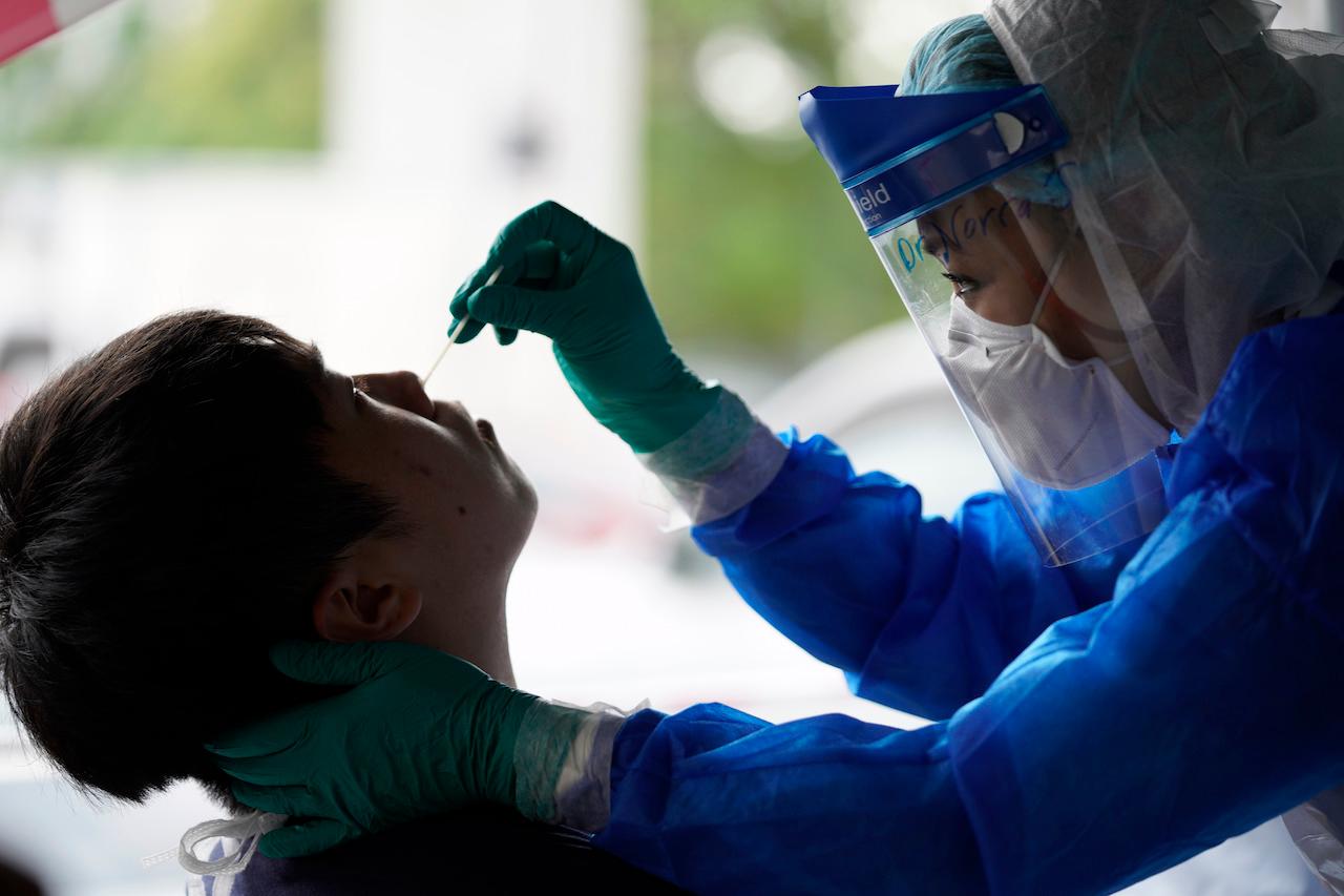 A health worker in Puchong takes a sample to be tested for Covid-19. Photo: AP