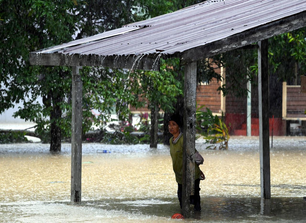Seorang penduduk Kampung Galing, Kuantan, Noriah Kasim, 65, termenung menantikan hujan berhenti selepas rumahnya dilanda banjir. Gambar: Bernama