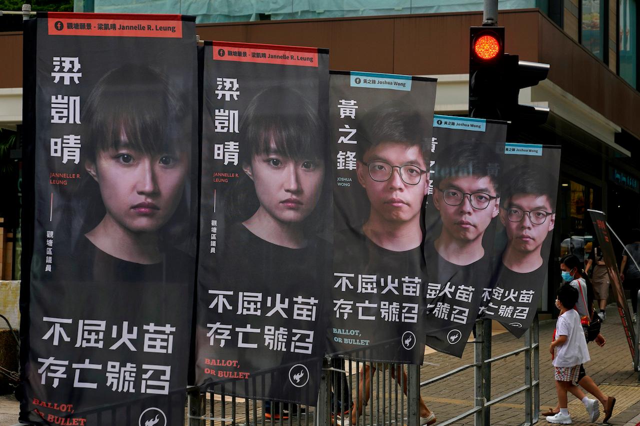 Banners showing pro-democracy candidate Joshua Wong (in glasses) displayed outside a subway station in Hong Kong. About 50 Hong Kong pro-democracy figures have been arrested by police under a national security law, following their involvement in an unofficial primary election last year held to increase their chances of controlling the legislature. Photo: AP