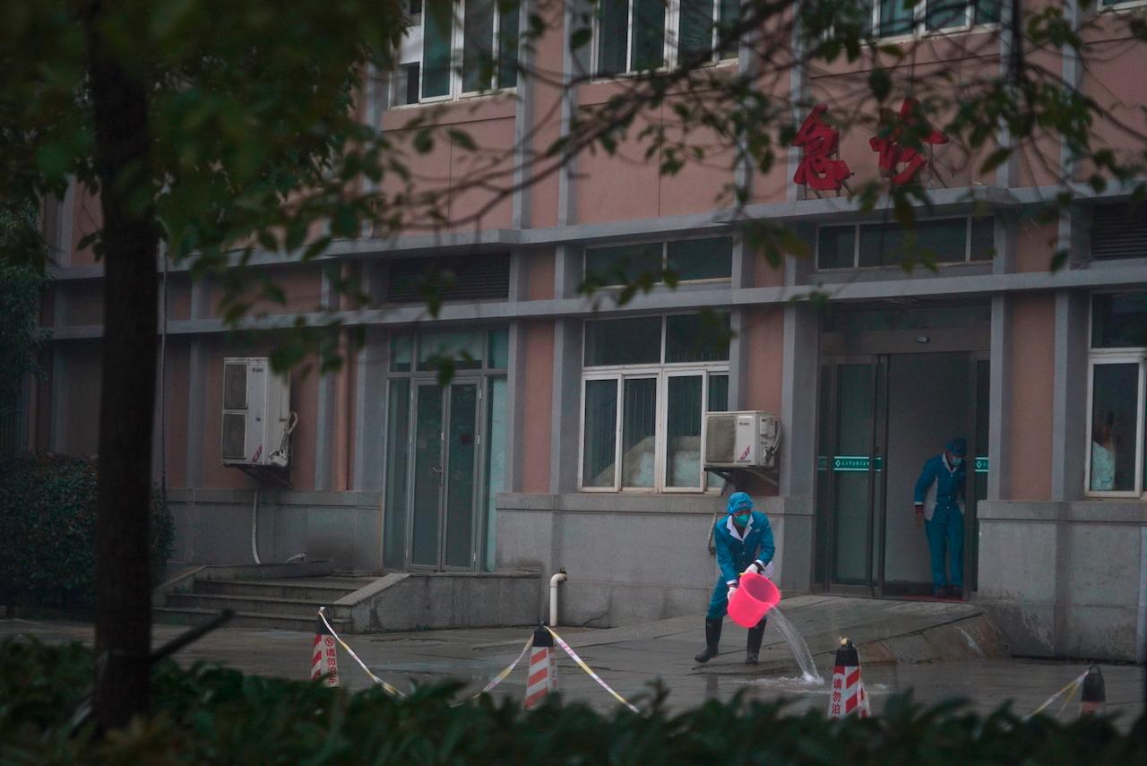Hospital staff wash the emergency entrance of Wuhan Medical Treatment Center, where some patients infected with Covid-19 were treated in this file picture taken Jan 22, 2020. Photo: AP