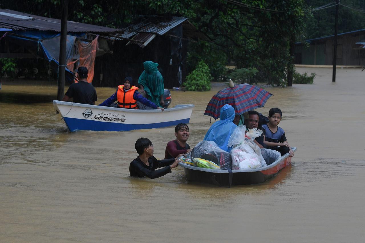 Members of the Civil Defence Force help residents whose homes were flooded after heavy rain in Dungun, Terengganu. Photo: Bernama