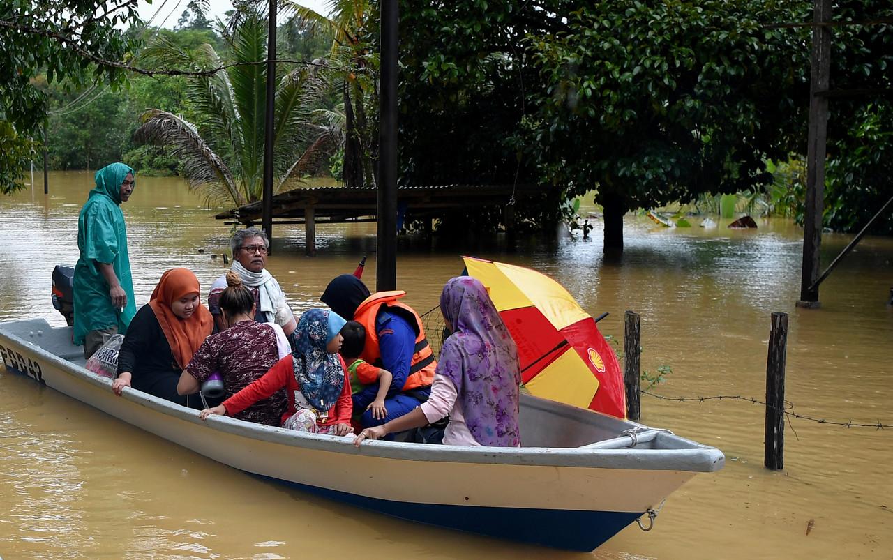 Anggota Angkatan Pertahanan Awam Malaysia (APM) menggunakan bot bagi menyelamatkan penduduk yang terjejas banjir berikutan hujan lebat di Kampung Belimbing, Jongok Batu, Dungun, semalam. Gambar: Bernama