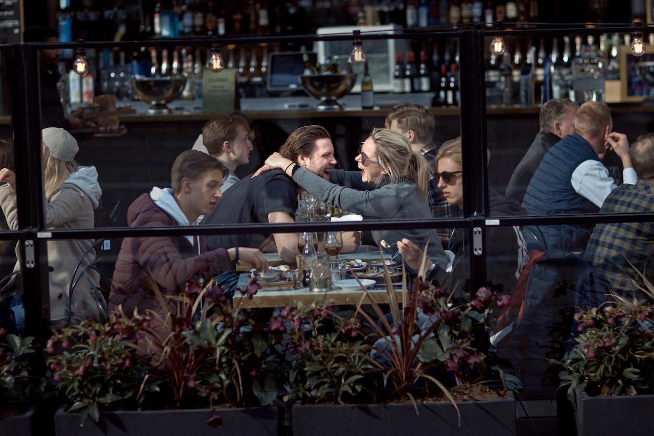 Customers laugh and chat at a restaurant in Stockholm, Sweden, at the start of the pandemic in April 2020. Sweden controversially relied on mostly non-coercive measures up to now. Photo: AP