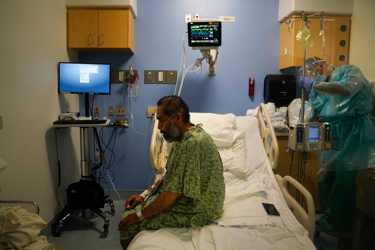 A Covid-19 patient sits in bed during an exercise session with his therapist at a hospital in Orange, California, Jan 7. Photo: AP