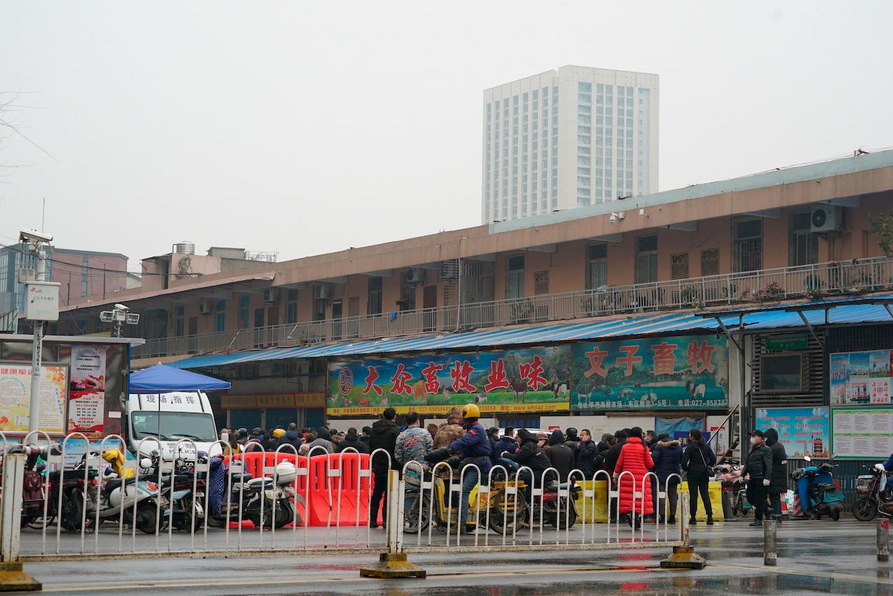 People gather outside the Wuhan Huanan wholesale seafood market where the Covid-19 outbreak was said to have started. Photo: AP