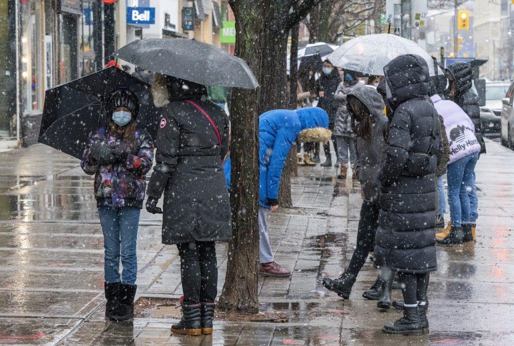 People line up in the snow outside a store in Toronto, Nov 22. Several politicians have apologised and resigned after it was found that they had travelled for vacations despite urging Canadians to stay home amid a surge in Covid-19 cases. Photo: AP