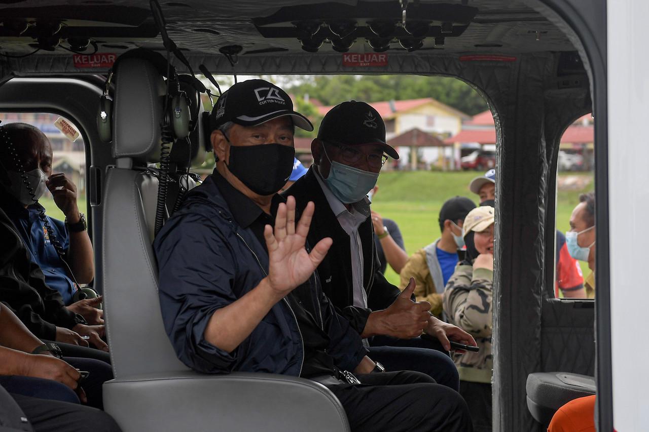 Prime Minister Muhyiddin Yassin waves from a helicopter before departing to visit flood victims in Chenor, Maran in Pahang, Jan 10. Photo: Bernama