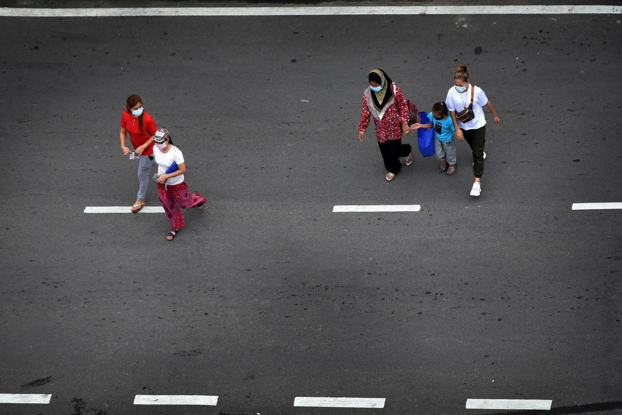 Pedestrians wearing face masks cross a road in Labuan, Jan 11. Photo: Bernama