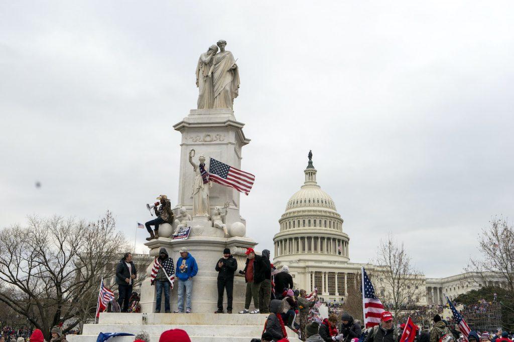 Supporters of President Donald Trump climb the Peace Monument, also known as the Naval Monument or Civil War Sailors Monument, during a rally at the US Capitol on Jan 6, in Washington. Photo: AP