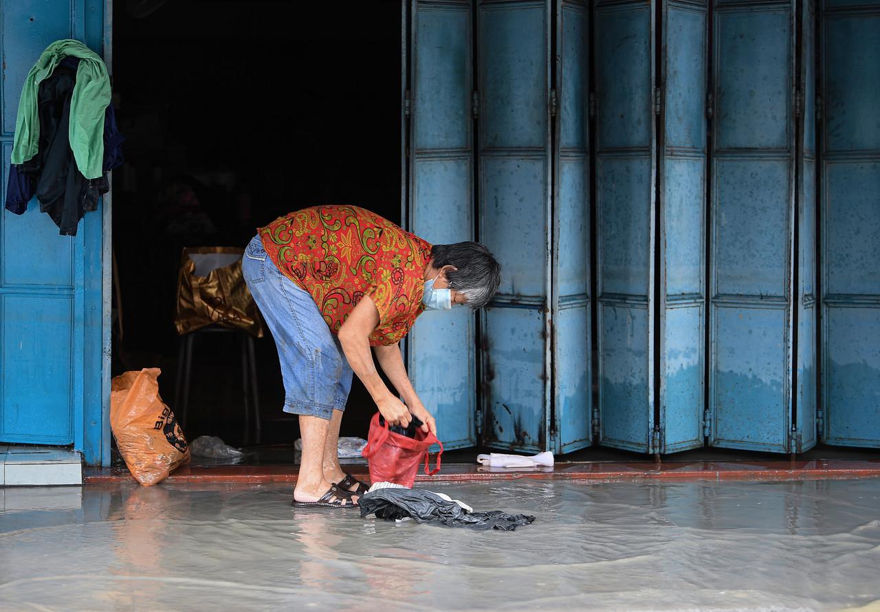 Pemilik premis perniagaan sekitar Bandar Kota Tinggi, Johor mula membersihkan kedai masing-masing setelah keadaan banjir mulai surut ketika tinjauan di sekitar bandar tersebut pada 6 Januari lalu. Gambar: Bernama