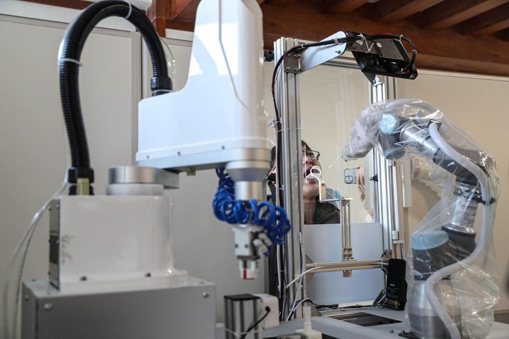 A robot takes a swab sample from a man to test for the Covid-19 coronavirus in Shenyang, in northeastern China's Liaoning province on Jan 13. Photo: AFP